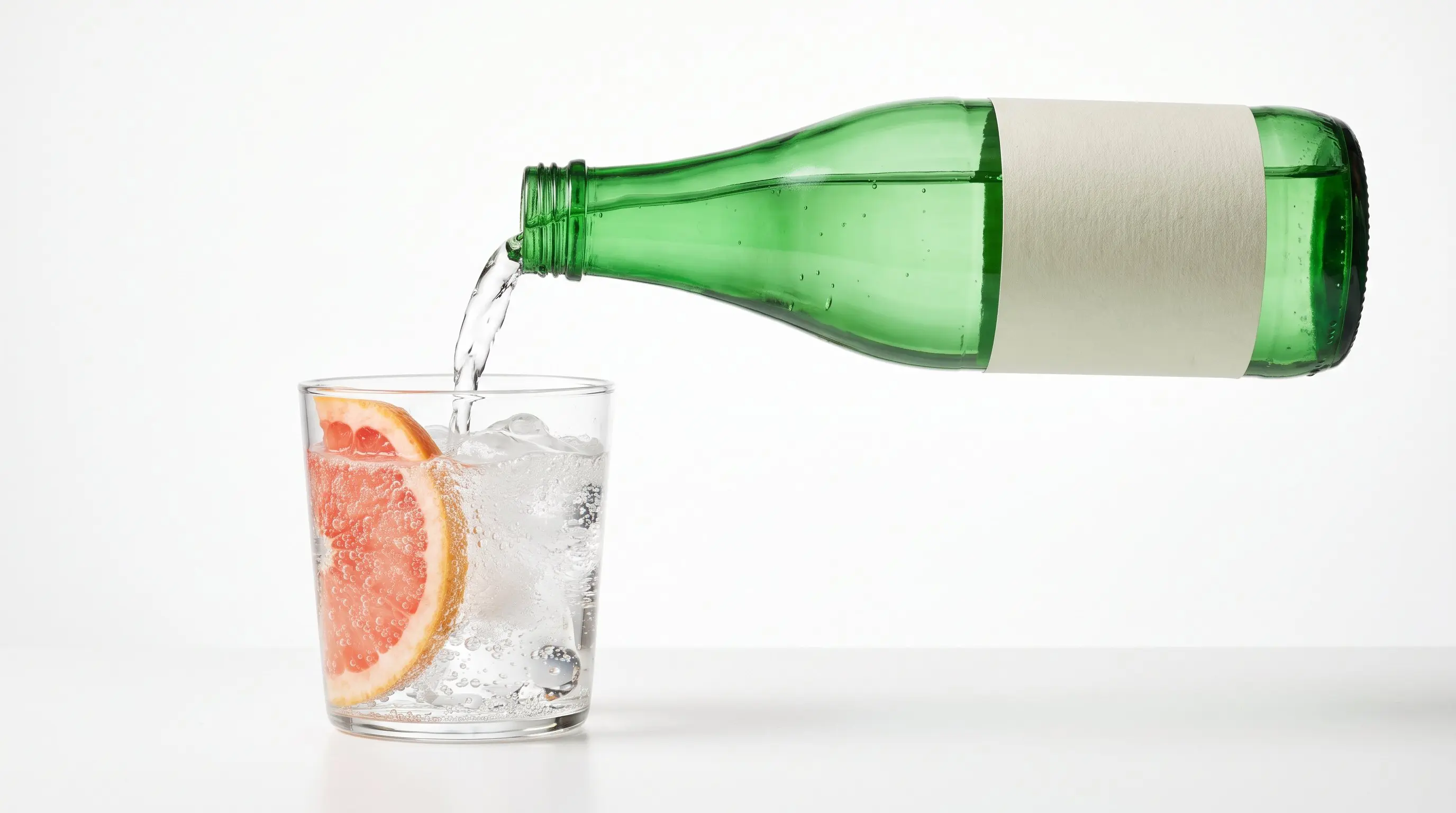 Sparkling mineral water pouring over ice and a grapefruit slice